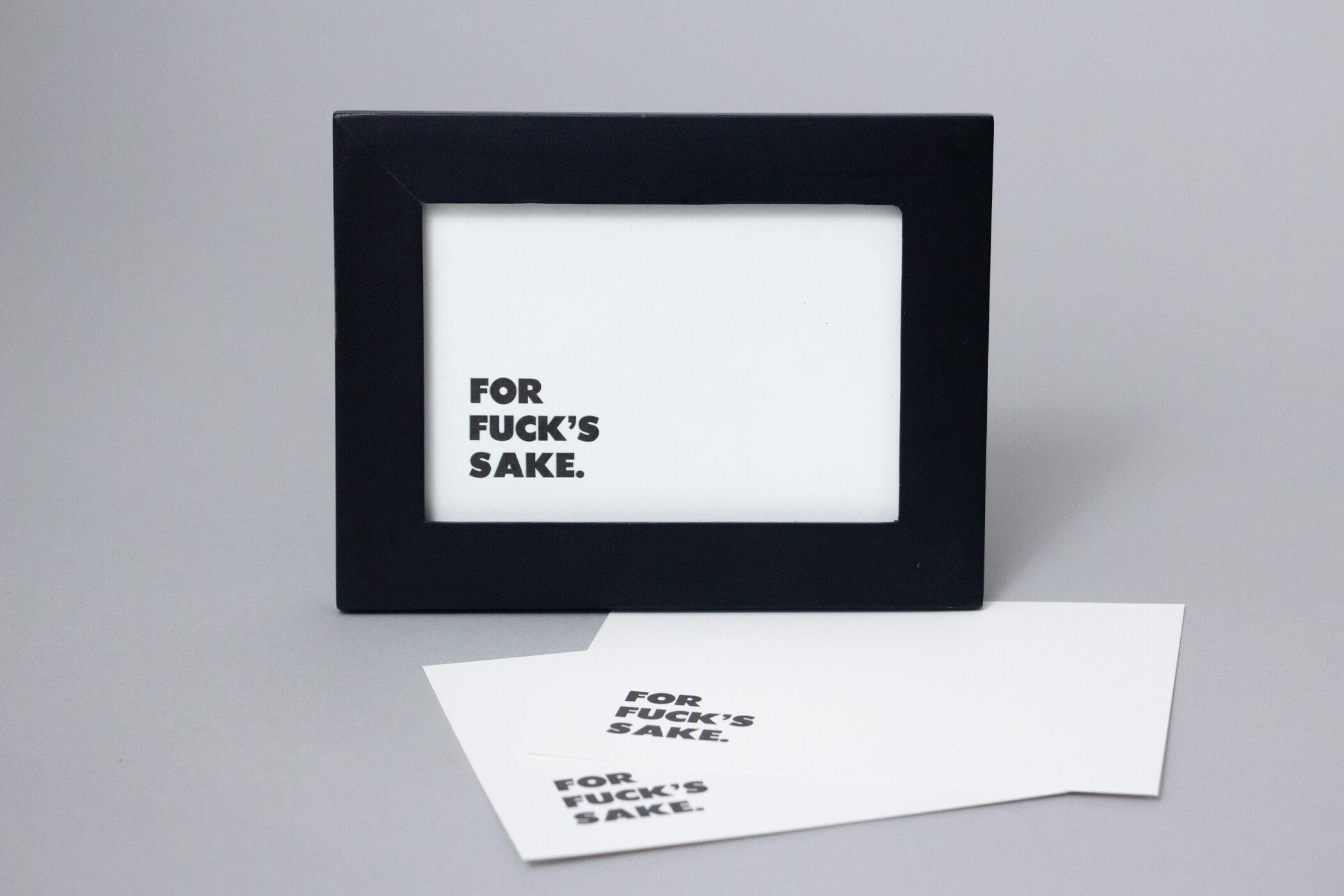 A minimal print that says 'FOR FUCK'S SAKE.' in the bottom left corner, in a black frame with two loose prints below it